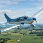 Small general aviation aircraft in flight with subtle data visualization overlay, representing data-driven safety monitoring in general aviation`