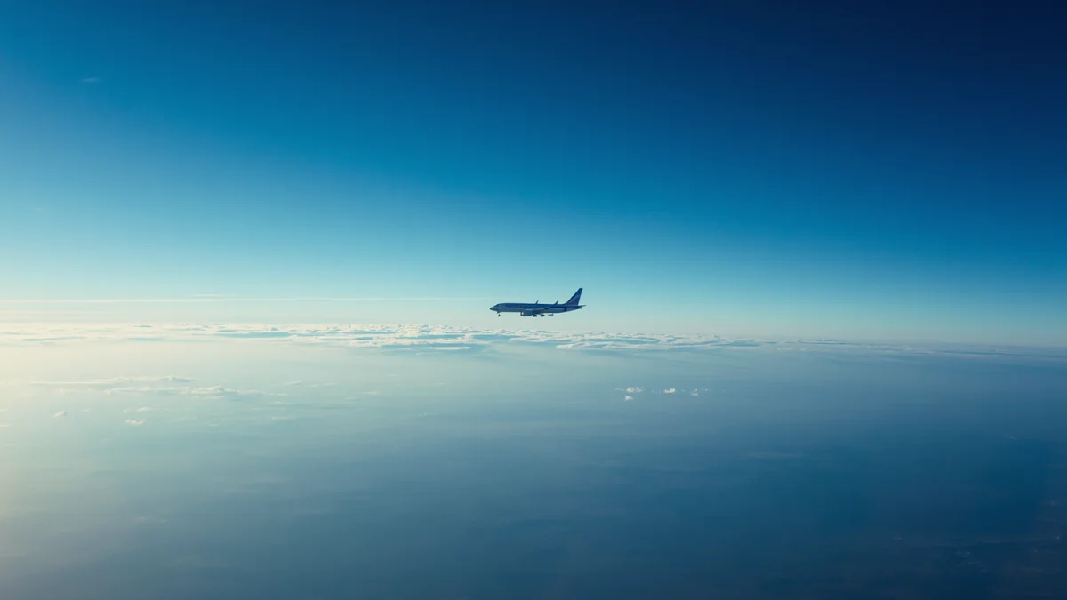 Commercial aircraft leaving contrails at cruise altitude, representing ICAO concerns over the proposed EU ETS expansion to international flights and its impact on CORSIA